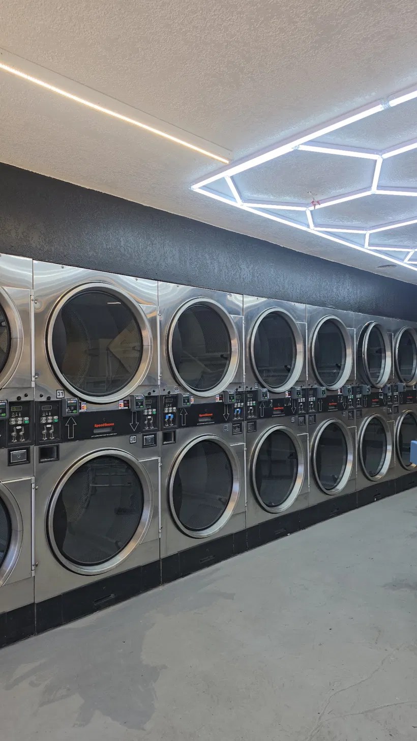 Industrial dryer bank with hexagonal LED lighting — the laundromat interior